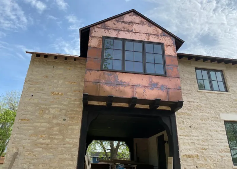 Copper metal panel facade on a stone building for Metal Roof Coating in Sioux Center