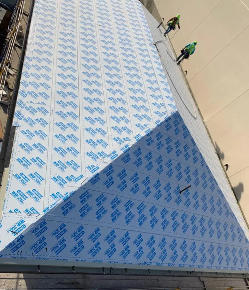 Professional roofers installing underlayment on a metal roof in Sioux Center